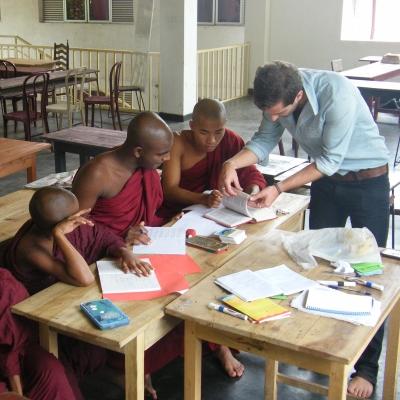 Monks in Sri Lanka get class assistance from a Projects Abroad volunteer teaching English in Sri Lanka A volunteer helps his students with their classwork during his teaching work experience in Sri Lanka